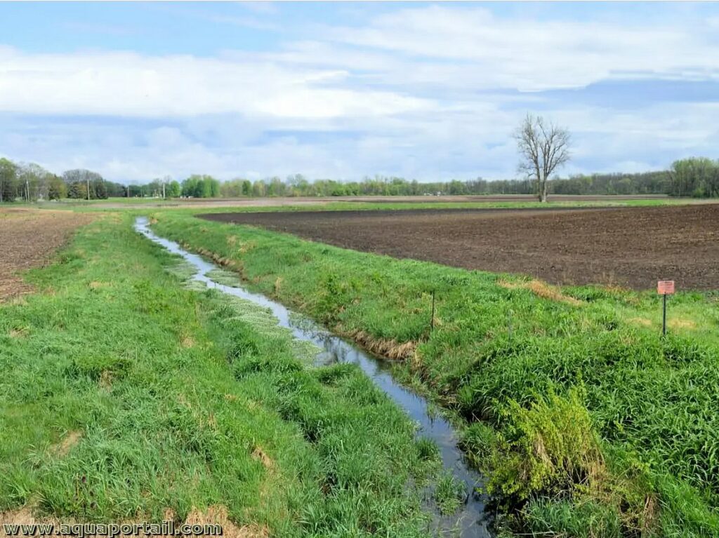 un ruisseau entouré de bandes enherbées puis de parcelles agricoles (sol nu)